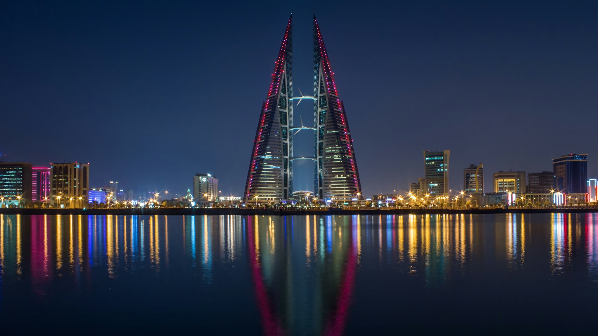 The Bahrain World Trade Center and Manama skyline lit up at blue hour