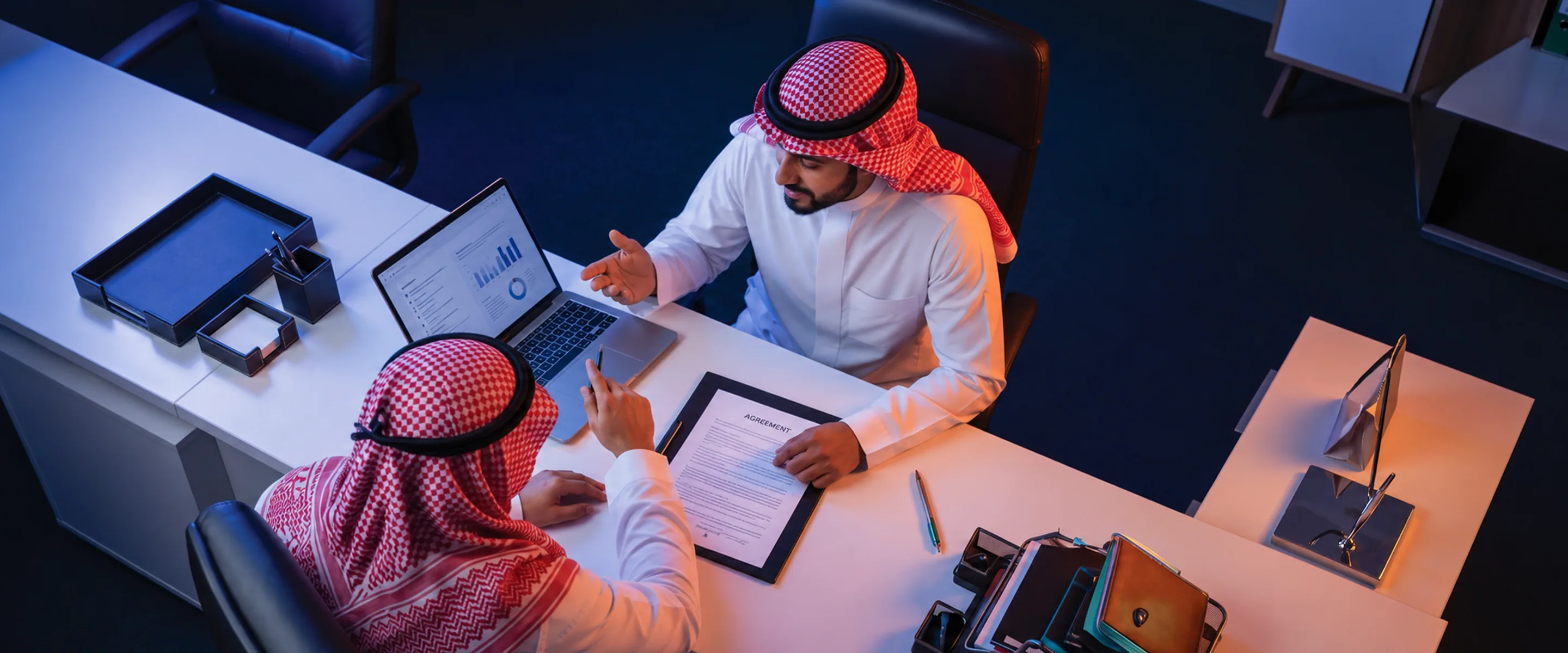 Two businessmen reviewing an agreement at a desk